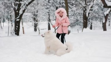 Samoyed köpeği olan bir çocuk.