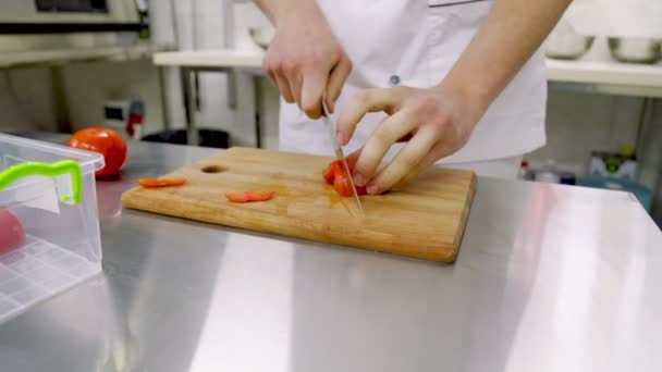 Schneiden einer Tomate auf einem hölzernen Tablett — Stockvideo