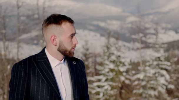 Bräutigam auf dem Hintergrund der schneebedeckten Berge — Stockvideo