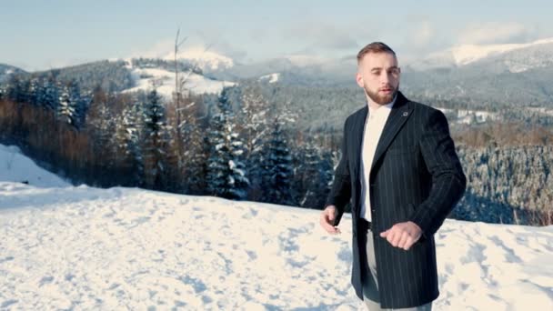 Brudgummen på bakgrunden av snötäckta berg — Stockvideo