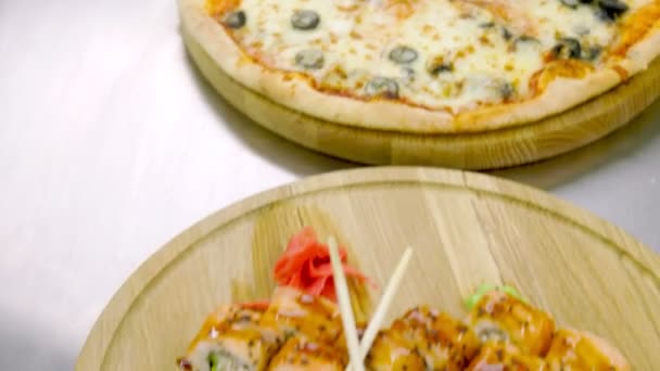 Tahta tepsilerde pizza ve suşi. — Stok video