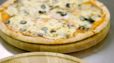 Tahta tepsilerde pizza ve suşi.