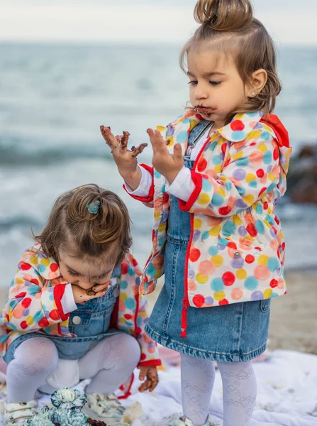 Children eating chocolate covered cake — Stock Photo, Image