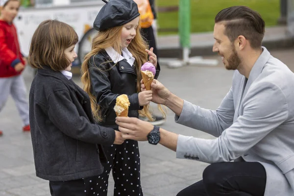 Ο άνθρωπος δίνει παγωτό στα παιδιά. — Φωτογραφία Αρχείου