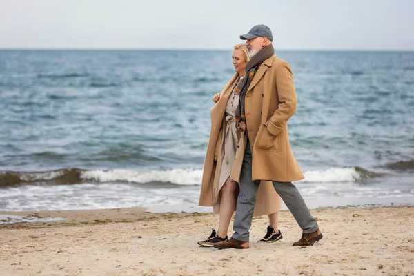 Пожилая пара прогуливаясь по морю — стоковое фото