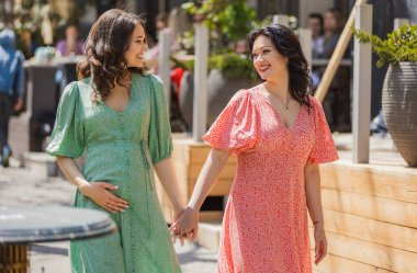 Anne ve kızı şehir sokaklarında yürüyor.