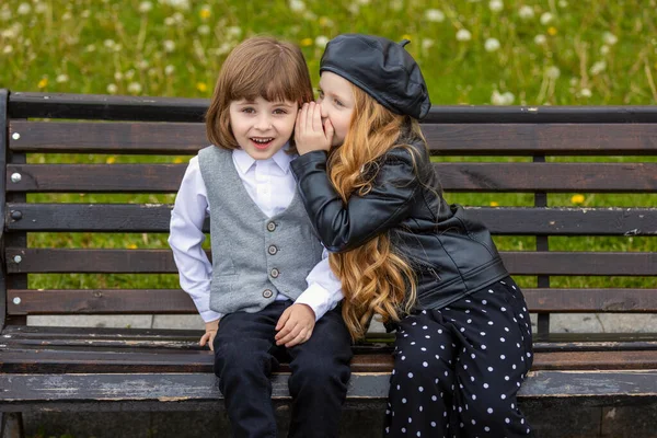 Children sit on a bench in the city — Stock Photo, Image