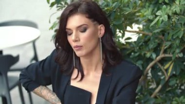 Masada takım elbiseli güzel bir kadın oturuyor.