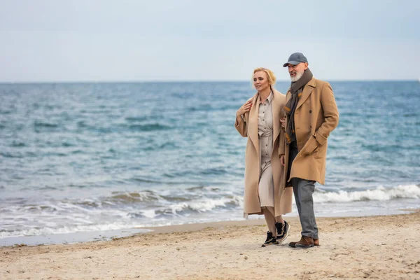 Пожилая пара прогуливаясь по морю — стоковое фото