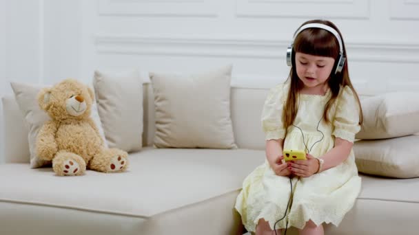 Menina com fones de ouvido cantando uma canção — Vídeo de Stock