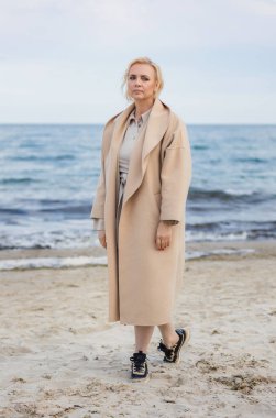 Kumsalda yürüyen yaşlı bir kadın