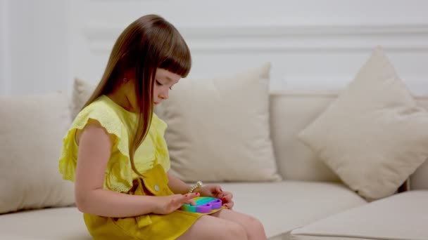 Chica jugando con un juguete pop él — Vídeos de Stock