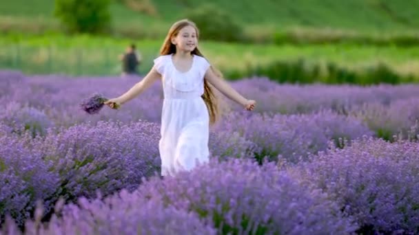 En flicka som springer på ett lavendelfält — Stockvideo