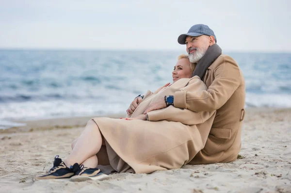 Pareja de ancianos sentados en la playa —  Fotos de Stock