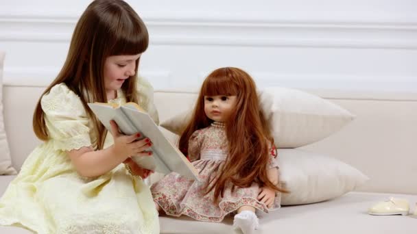 Девушка играет с куклой — стоковое видео