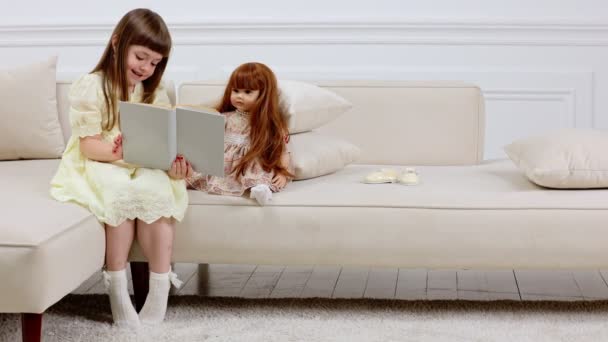Menina brincando com uma boneca — Vídeo de Stock