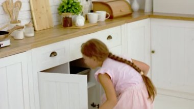 Kız mutfakta bir şey arıyor.
