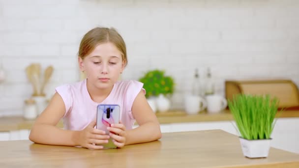 A menina olha para o telefone — Vídeo de Stock