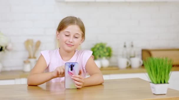 A menina olha para o telefone — Vídeo de Stock