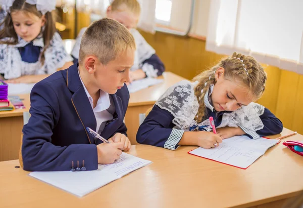 Mädchen und Junge am Schreibtisch — Stockfoto