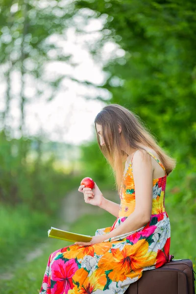 Flicka med böcker och äpple — Stockfoto