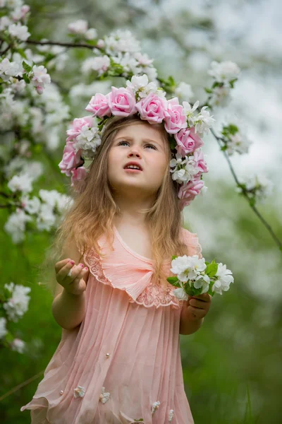 Kleines Mädchen in einem blühenden Garten — Stockfoto