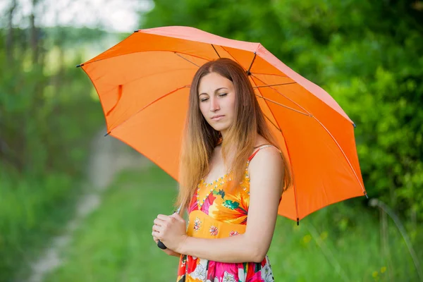 Mädchen mit orangefarbenem Regenschirm — Stockfoto