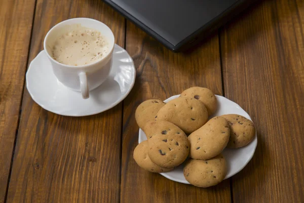 Computer a cup of coffee and cookies — Stock Photo, Image