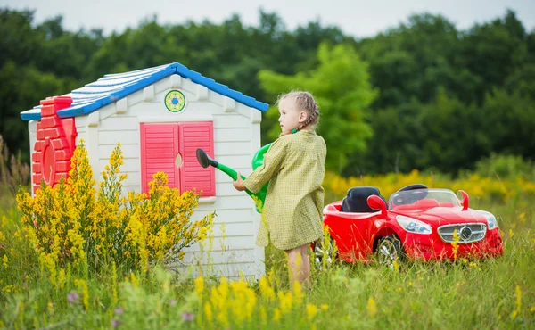 Kleines Mädchen gießt Blumen — Stockfoto