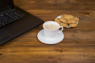 bilgisayar bir fincan kahve ve kurabiye