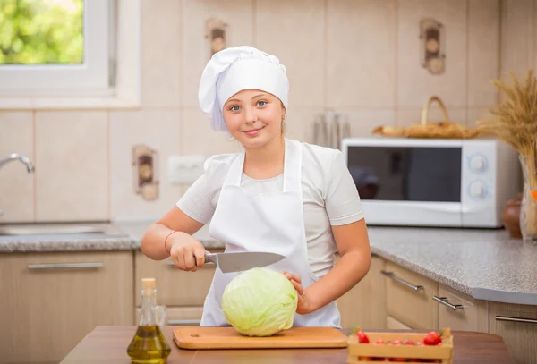 Girl cook cuts cabbage — Stock Photo, Image
