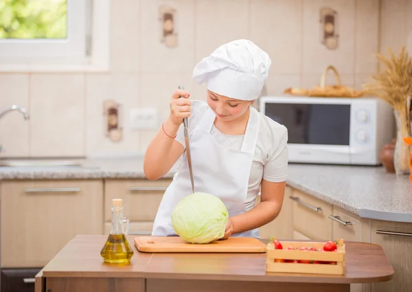 Girl cook cuts cabbage — Stock Photo, Image