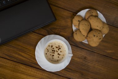 bilgisayar bir fincan kahve ve kurabiye