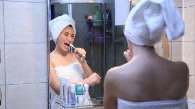 bir aynanın önünde şarkı söyleyen kız