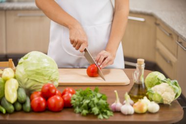 Kız cook bir domates keser