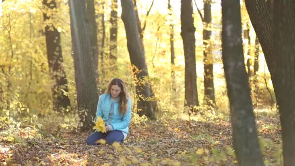 Девушка с листьями в руках — стоковое видео