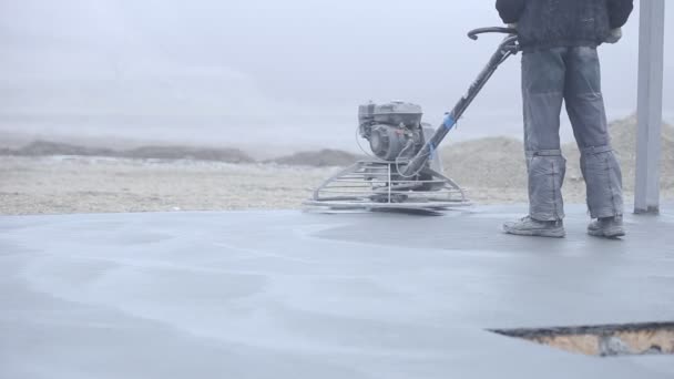 Travailleur lisse la surface du béton — Video