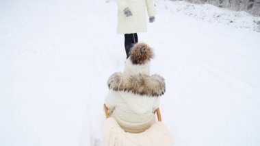 Anne bebek bir kızak üzerinde rulo