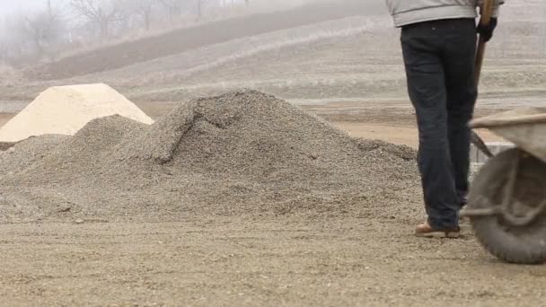 Worker throwing gravel into the cart — Stock Video