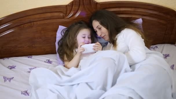 Mom with a child watching at phone — Stock Video