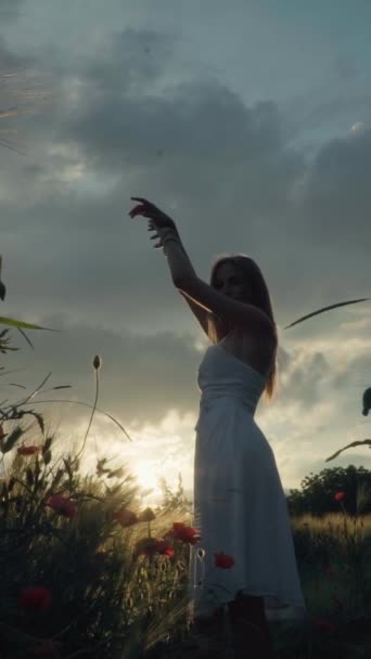 Linda chica bailando en un campo de amapola sonriendo felizmente. Orientación vertical — Vídeo de stock