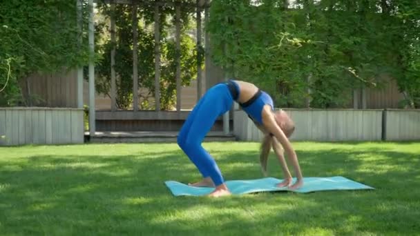 Woman practises yoga at sunrise in pine forest — Stock Video