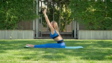 Spor kıyafetli sarışın kadın yoga yapıyor.