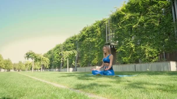 Fille méditant assis. jeune femme faisant de l'exercice de yoga — Video