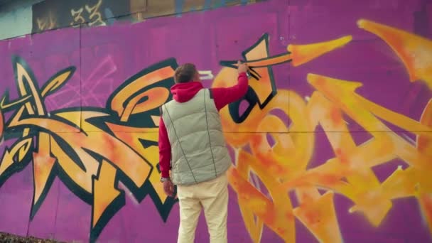 Graffiti művész festés a falon. Spray festék fal graffiti — Stock videók