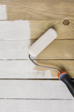 Ahşap çit bir fırça rulo tarafından boyanan parçası.