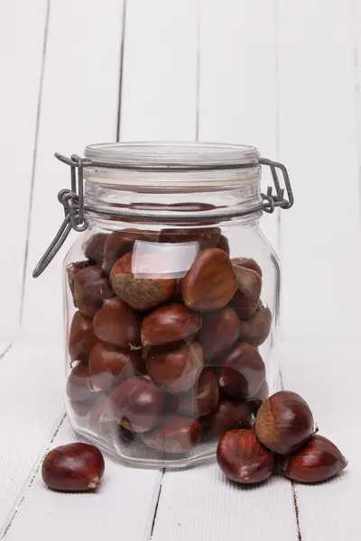 Vaso di vetro pieno di castagne — Foto Stock