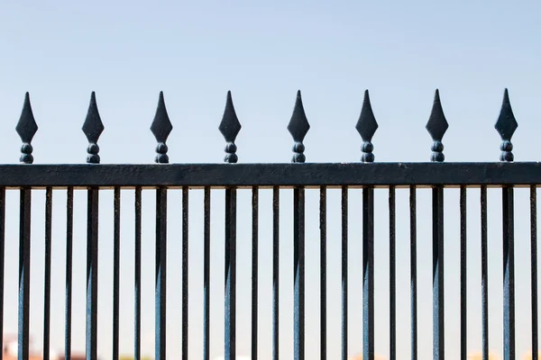 iron forged fence over a blue sky