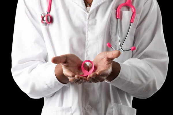 dark skin doctor with pink stethoscope and pink awareness breast cancer ribbon, on a black background.