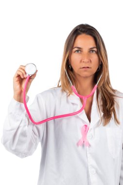 Beyaz arka planda pembe steteskop ve meme kanseri için pembe farkındalık kurdelesi olan genç ve güzel bir doktor kadın..